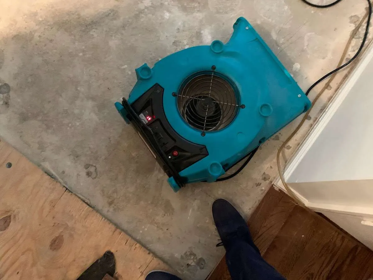 Air mover drying subfloor during Commercial Water Damage Restoration in Centerton